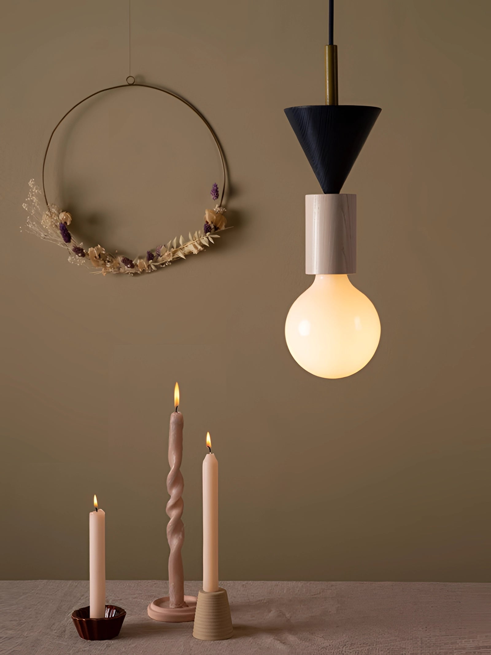 Modern geometric LED pendant light made of colorful wood blocks hanging from the ceiling, emitting warm light.