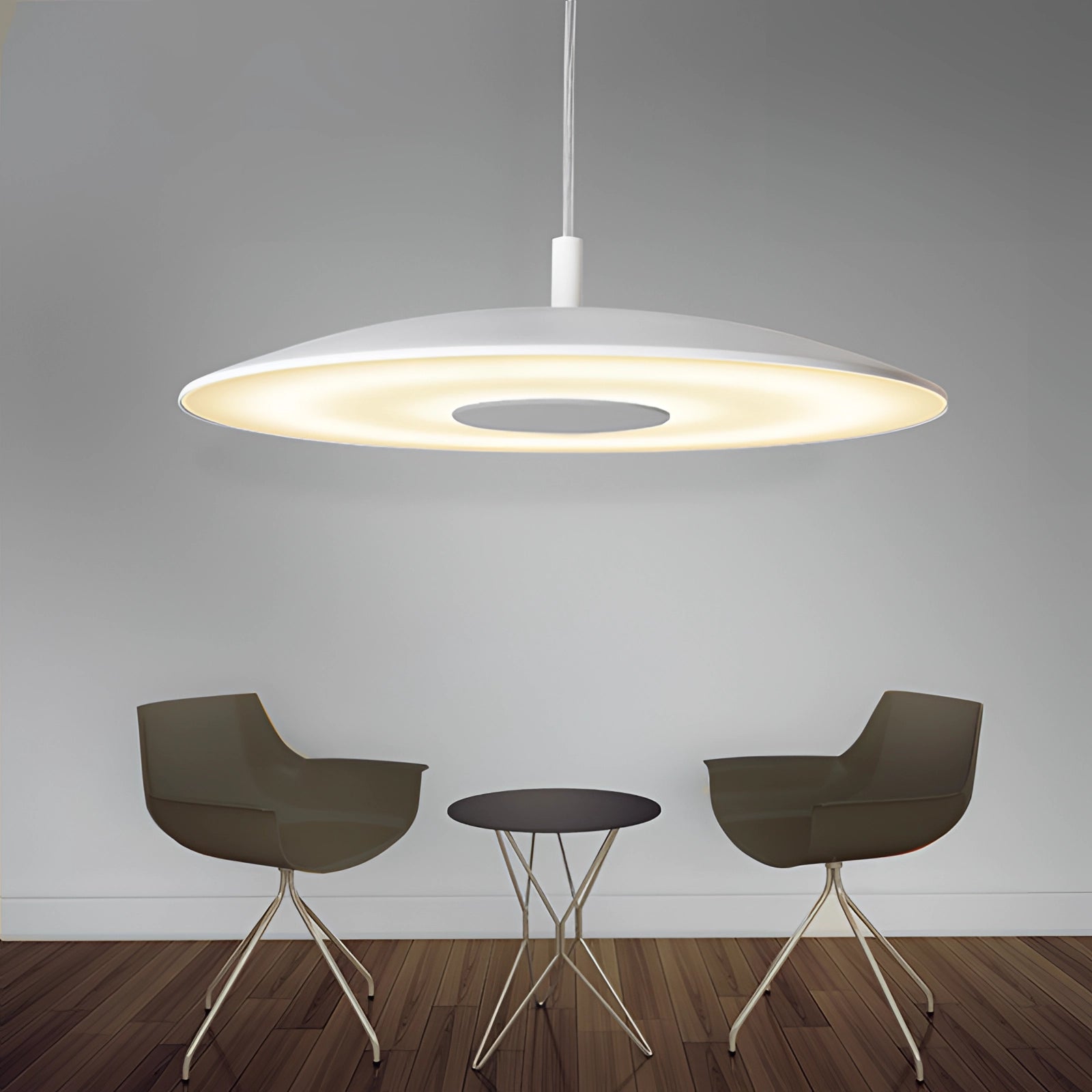 Modern gold-brushed pendant light with a white finish hanging over a sleek dining table set, featuring wood flooring and contemporary interior design elements.
