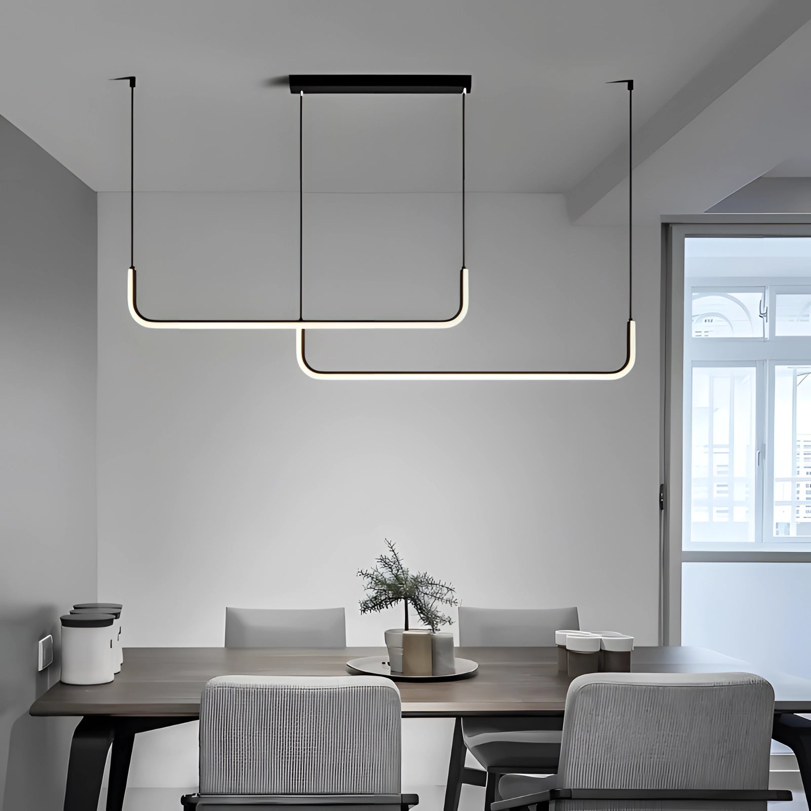 A modern LED pendant light with a geometric chandelier design hangs in a stylish living room featuring a wooden table, comfortable couch, large window, and indoor plant.