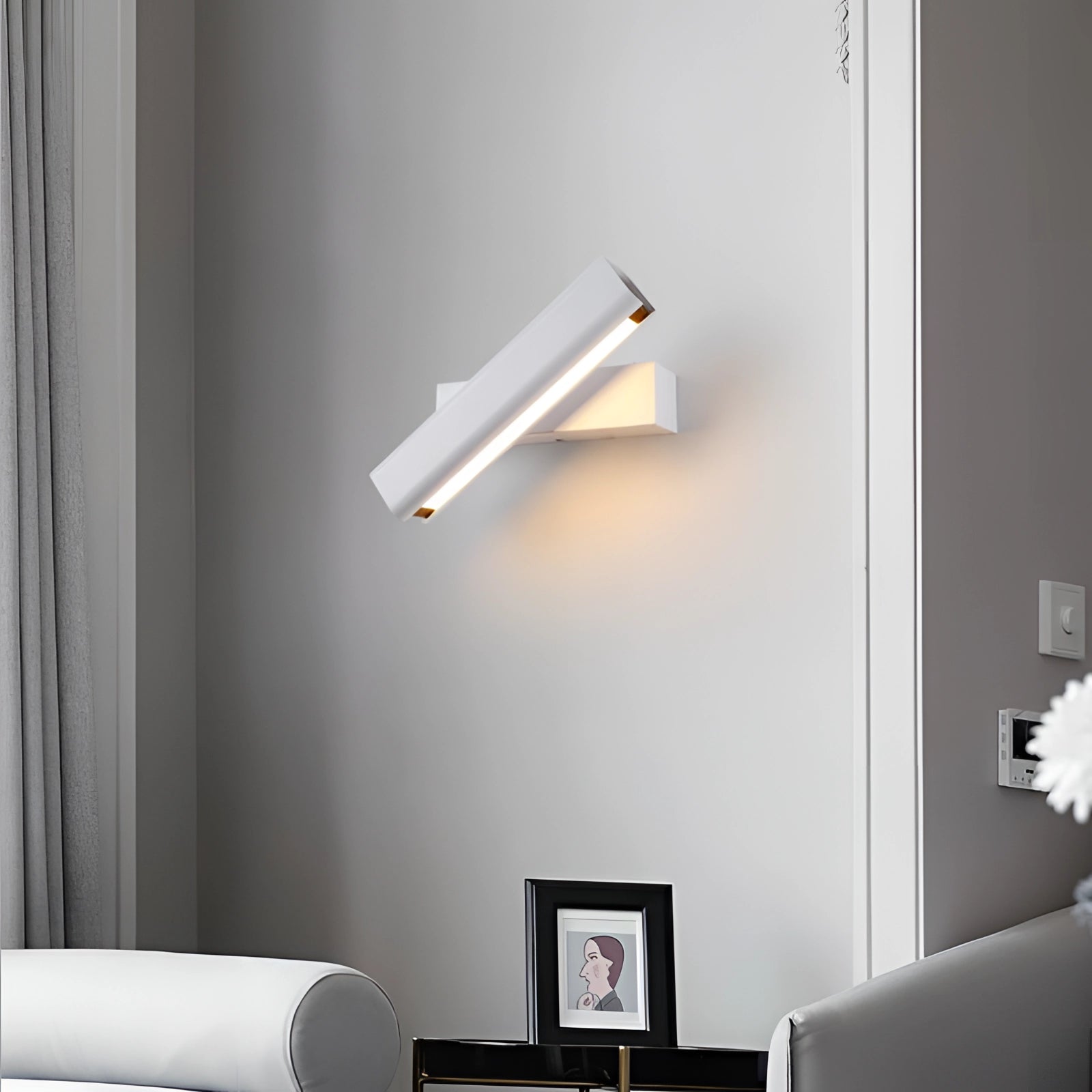Modern LED wall sconce with a black and gold design, featuring an adjustable rectangular shape in white, emitting cold white light, suitable for stylish interior design in a living room setting.