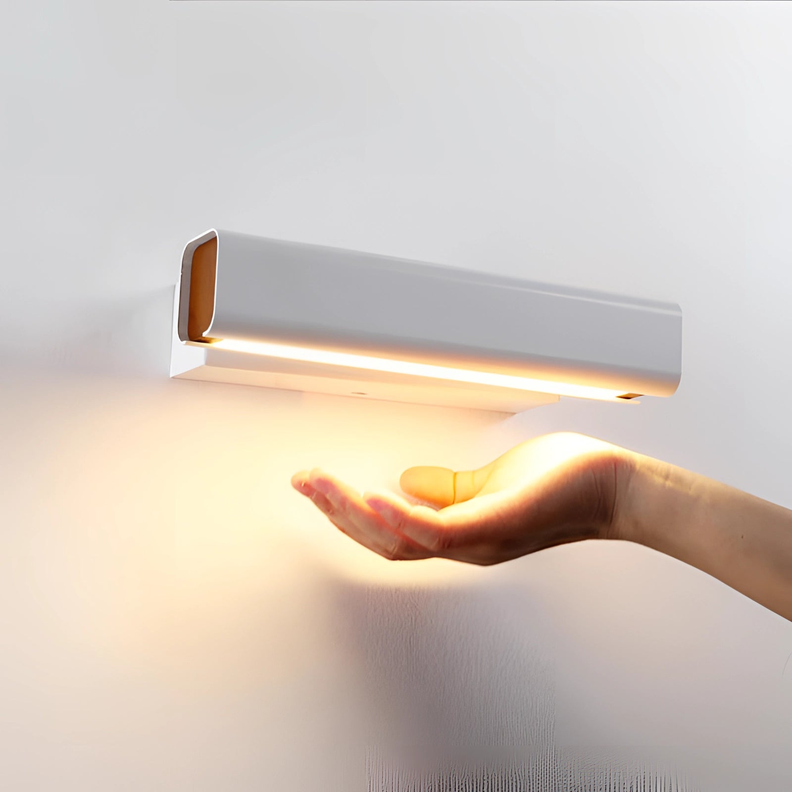 Modern LED wall sconce featuring an adjustable black and gold design with a sleek cylindrical shape, mounted on a wall in a contemporary setting.