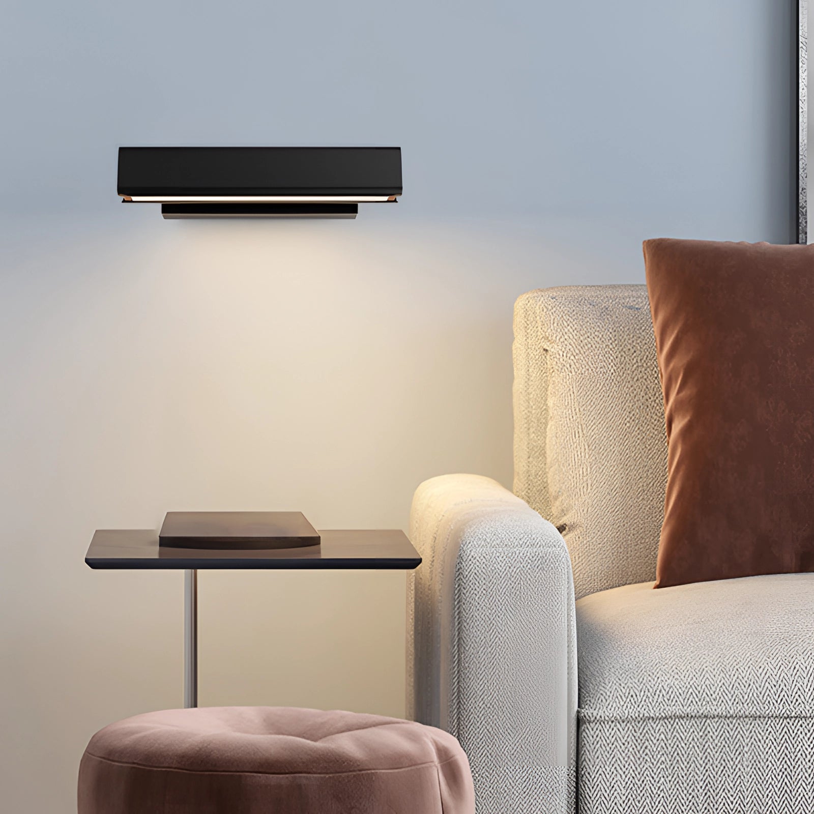 Modern LED wall sconce with an adjustable black and gold design, installed in a contemporary living room setting with hardwood flooring and a comfortable couch nearby.