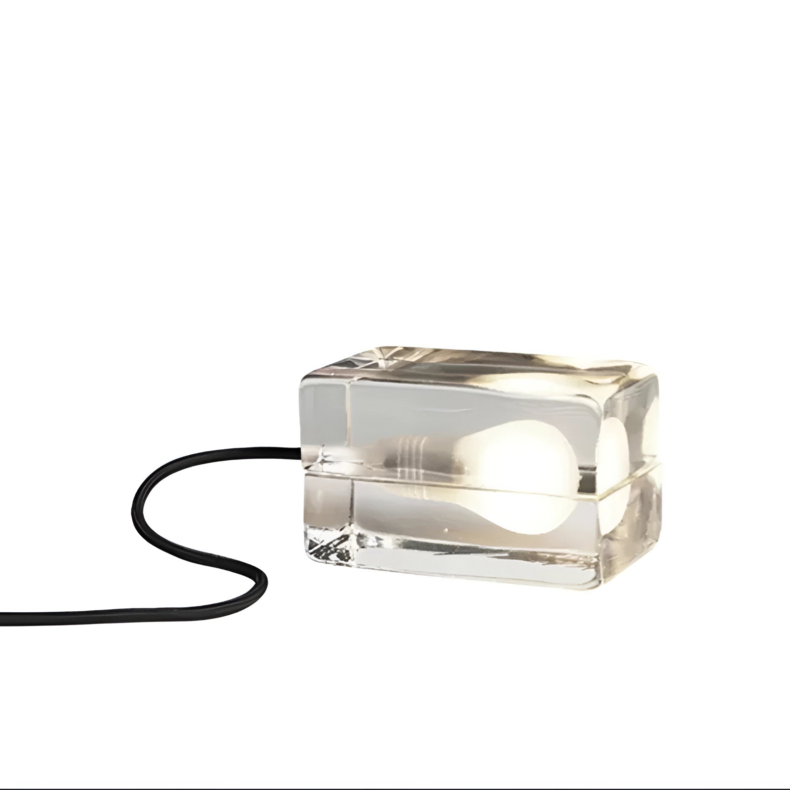 Modern minimalist clear glass cube table lamp with a black base, featuring a sleek design and decorative lighting, including visible cables and metal accents.