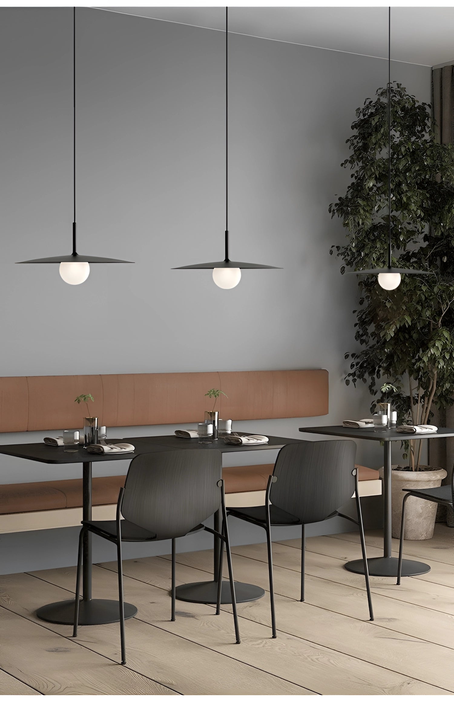 Modern minimalist LED pendant light with a Scandinavian dual-tone design hanging above a stylish table, surrounded by sleek wooden furniture, a plant, and a tastefully decorated interior showcasing contemporary flooring and wall accents.