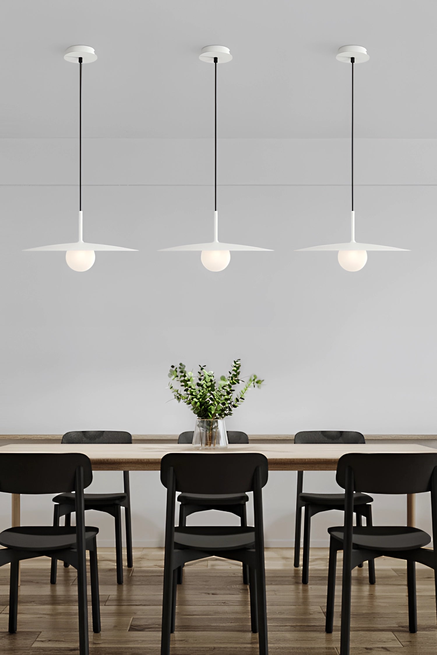 Modern minimalist Scandinavian dual-tone LED pendant light hanging above a white table and chair in a stylish interior setting with a touch of greenery.