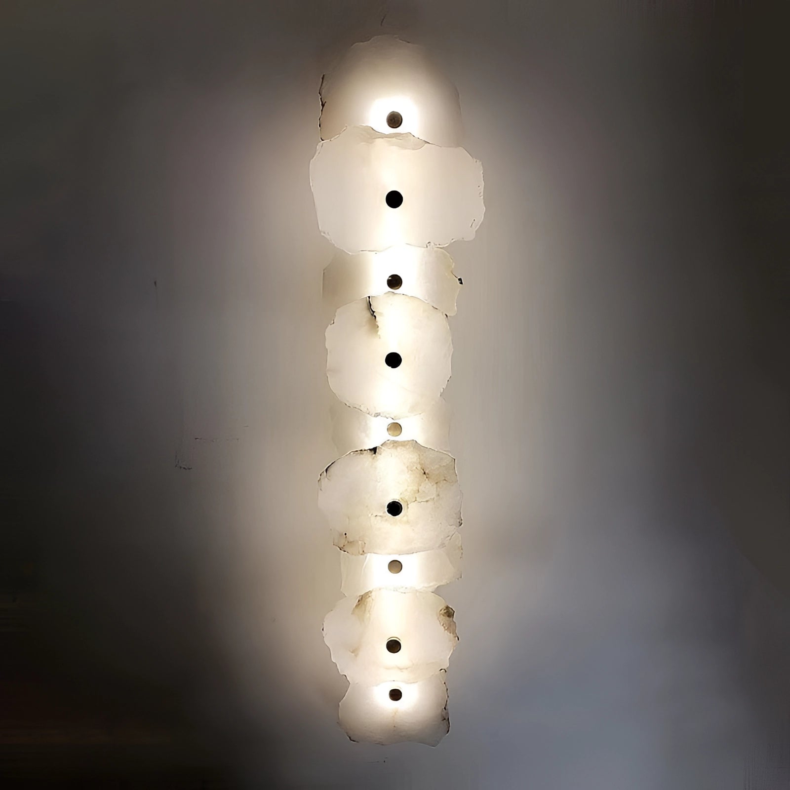 Modern minimalist LED wall lamp with a circular design, featuring a sleek metal finish. The lamp emits ambient light, creating a symmetrical pattern on the wall, suitable for enhancing interior decor in Great Britain or Australia with a voltage of 220 V-240 V. The photo is taken in a dark setting to highlight the lamp's artistic design and lighting effect.