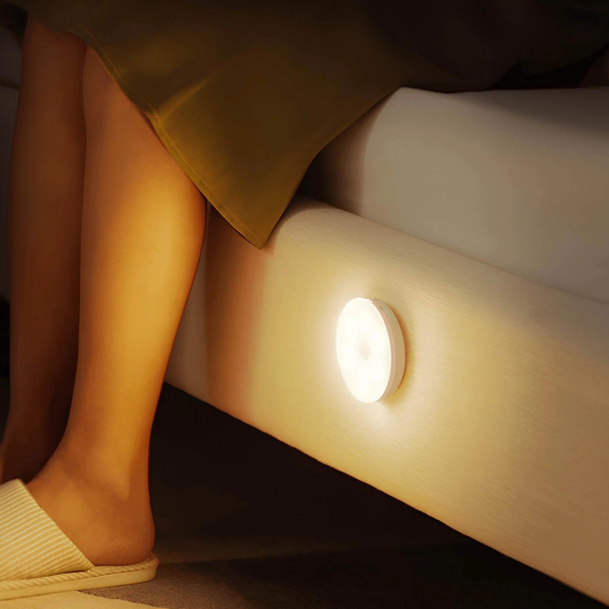 Modern minimalist wall lamp with a warm white LED light, featuring a sleek design and stylish decor elements, mounted on a wooden wall with beige flooring.