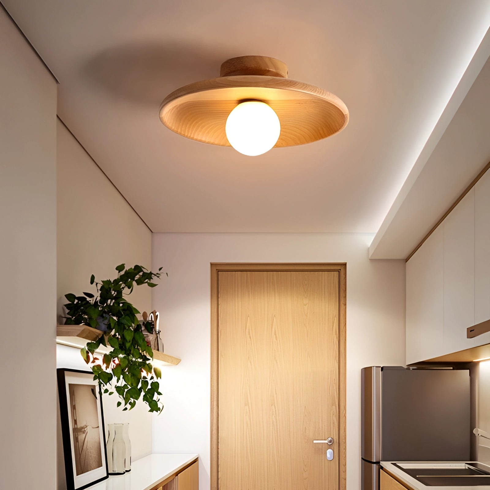 Modern minimalist warm-tone wooden ceiling light emitting a soft ambient glow in a stylish interior with wooden elements, a houseplant, and contemporary decor.