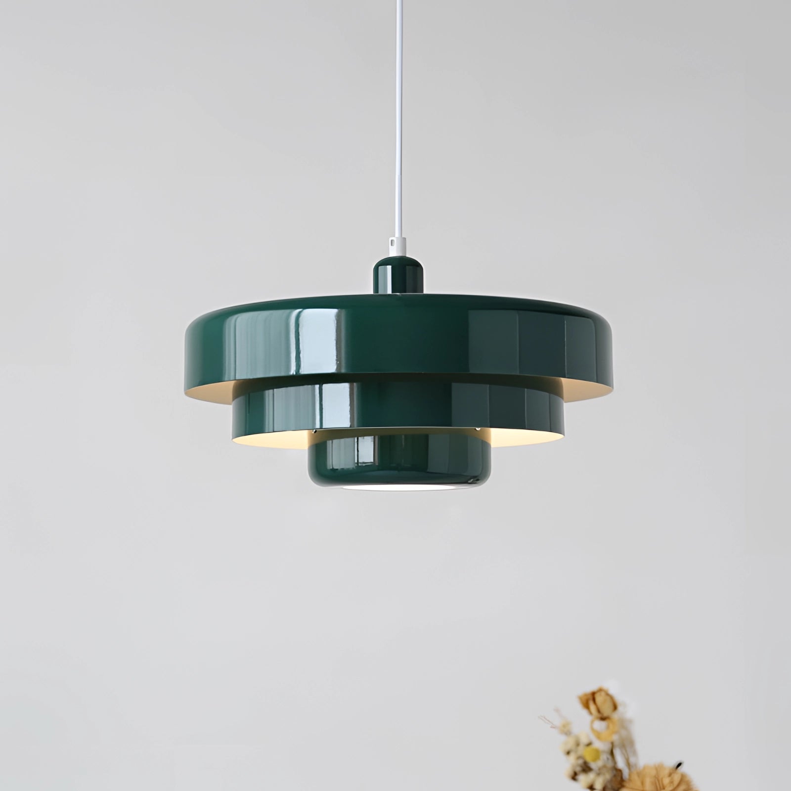 Modern orange pendant light with a cylindrical shape, hanging from the ceiling, featuring a Scandinavian and mid-century contemporary design.