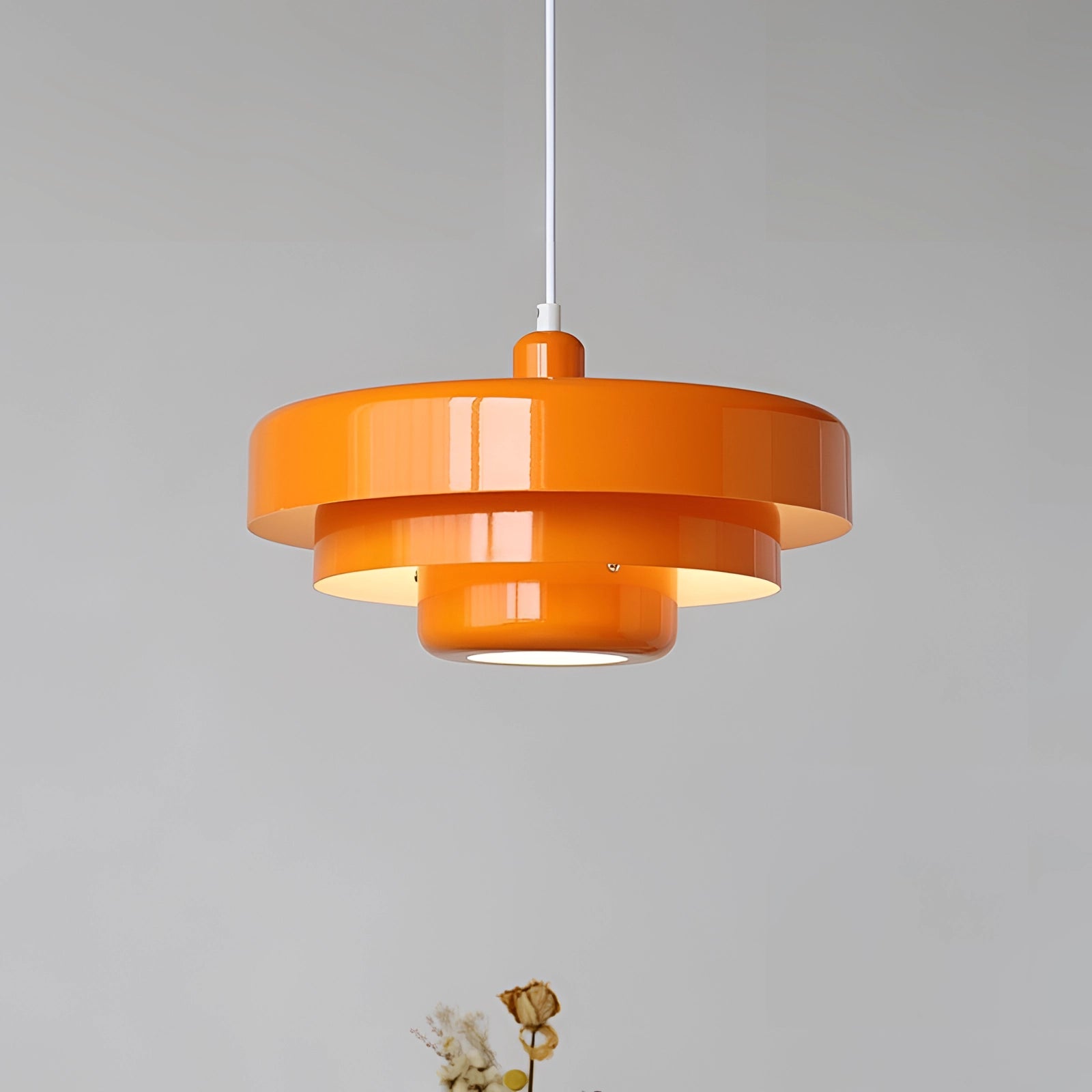Modern orange pendant light with a Scandinavian mid-century contemporary design hanging from the ceiling.