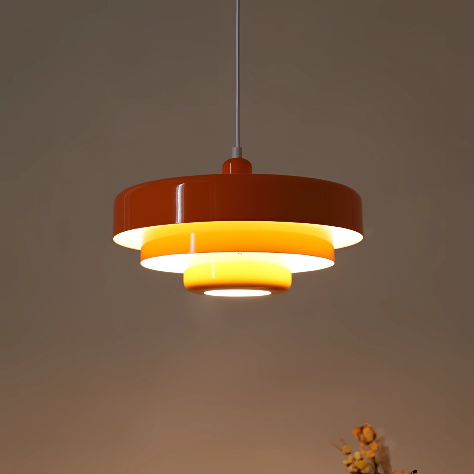 Modern orange pendant light with a Scandinavian mid-century contemporary design, hanging from the ceiling.