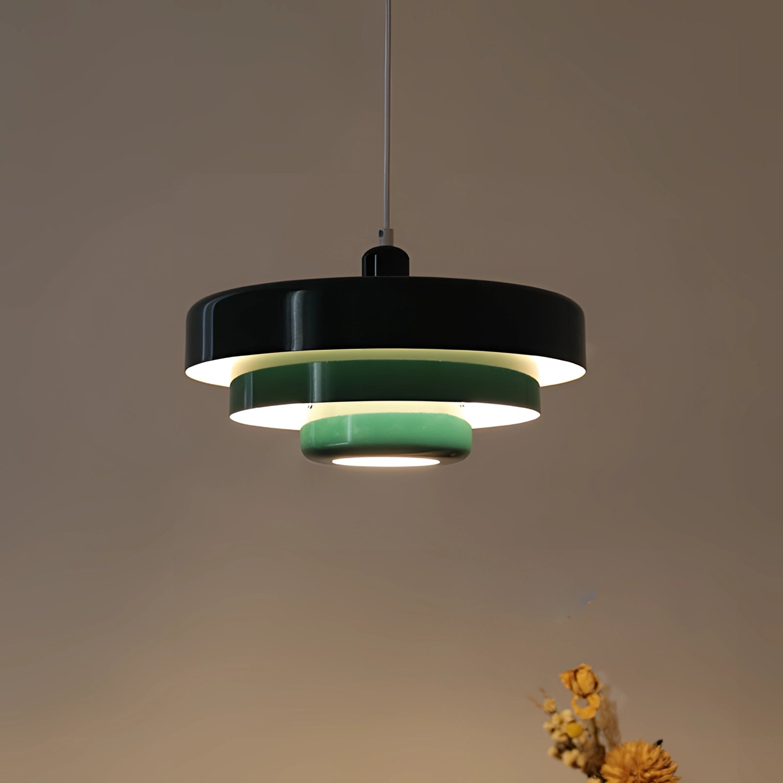 Modern orange pendant light with a Scandinavian and mid-century contemporary design, hanging in an outdoor setting against a sky background.