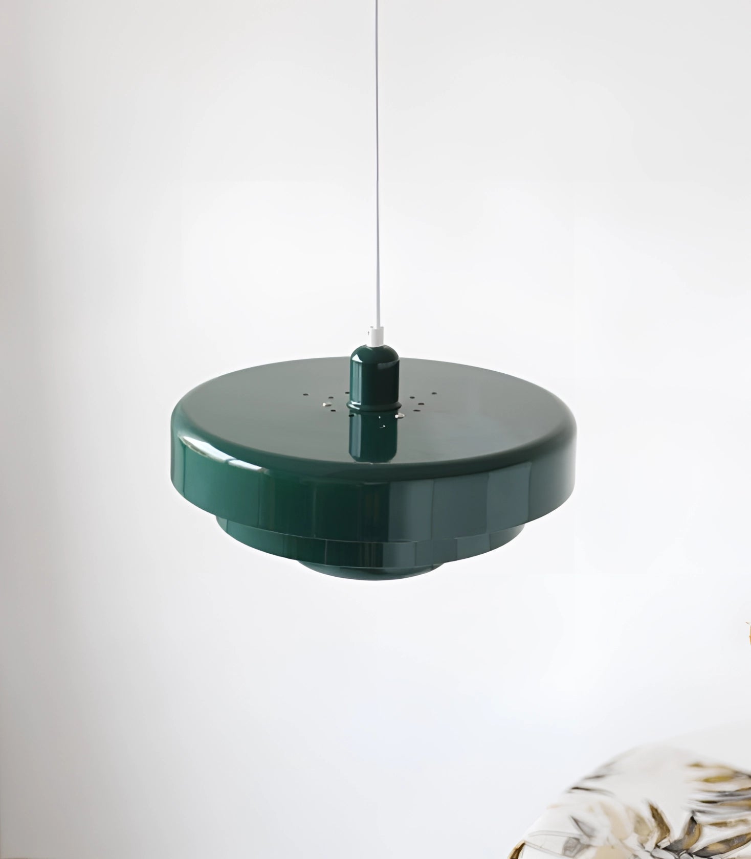 Modern orange pendant light with a sleek, circular design, hanging from the ceiling, illuminating a contemporary space with a Scandinavian and mid-century aesthetic.