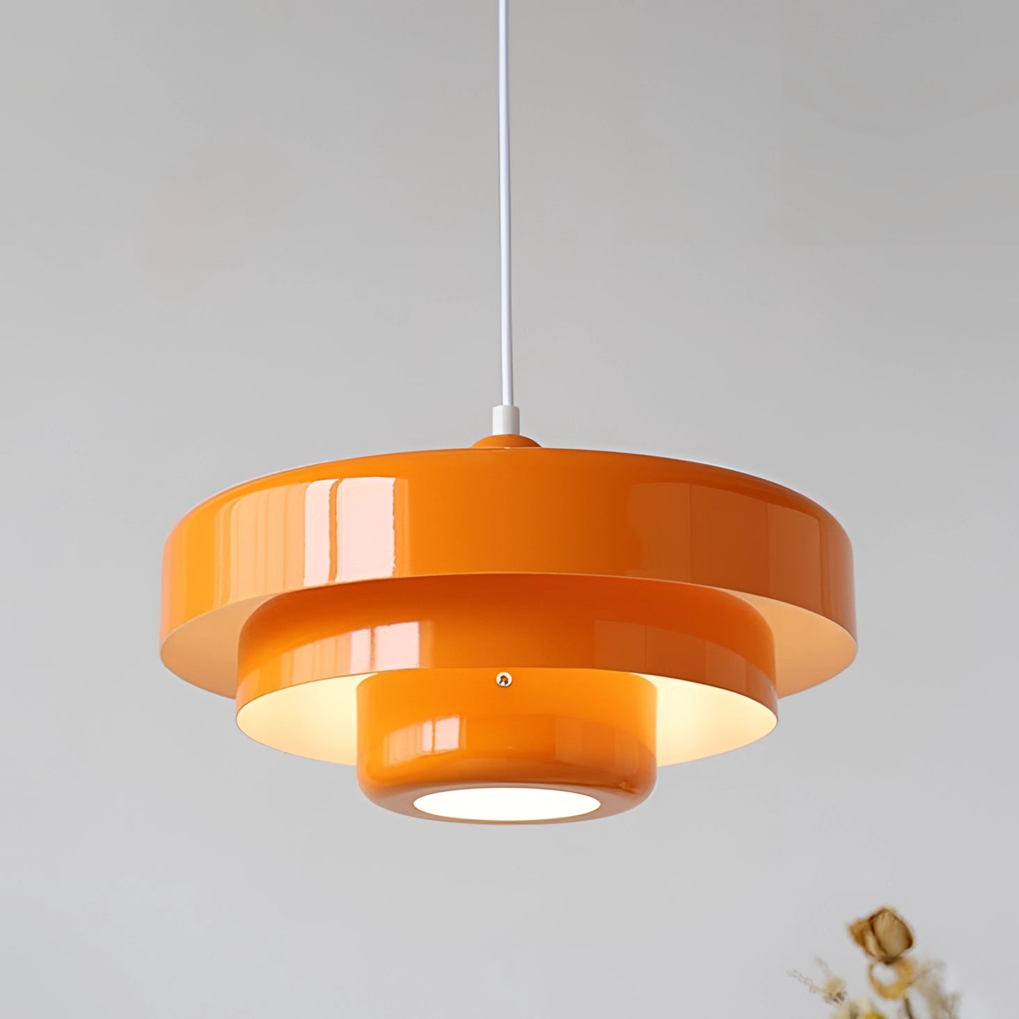 Modern orange pendant light with a sleek design, hanging from the ceiling, featuring Scandinavian and Mid-Century contemporary lighting elements.