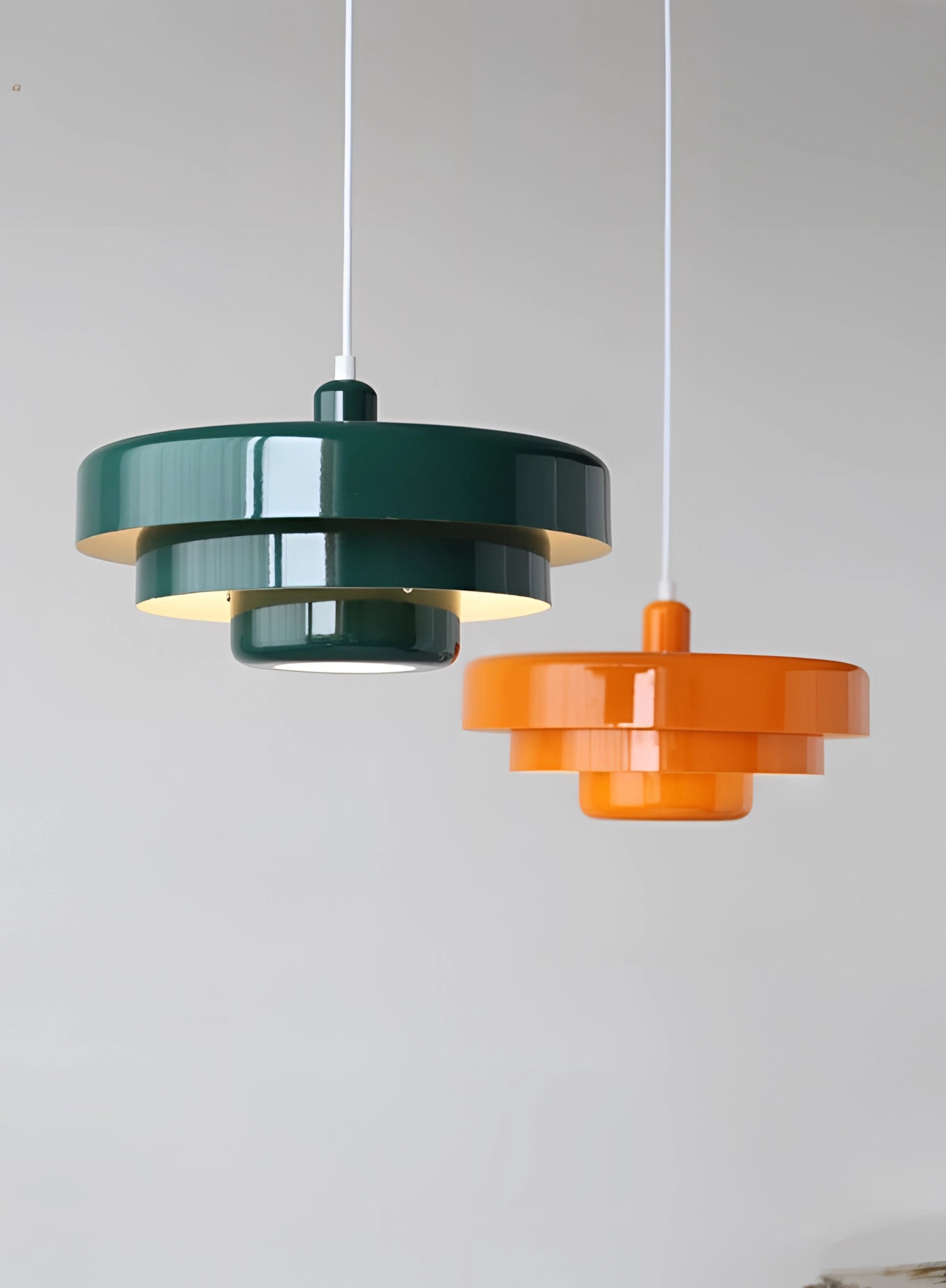 Modern orange pendant light with a cylindrical shape, wooden accents, and contemporary design, hanging from the ceiling.