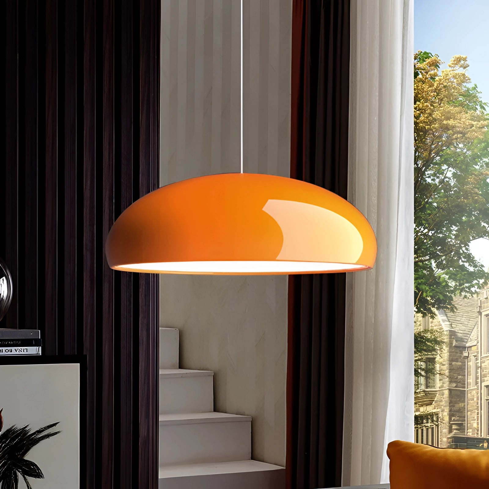 Modern oval pendant light with a white glass shade and yellow accents, hanging in a Scandinavian minimalist living room setting. The space features wooden furniture, a table, and a plant, creating a comfortable and stylish interior design.