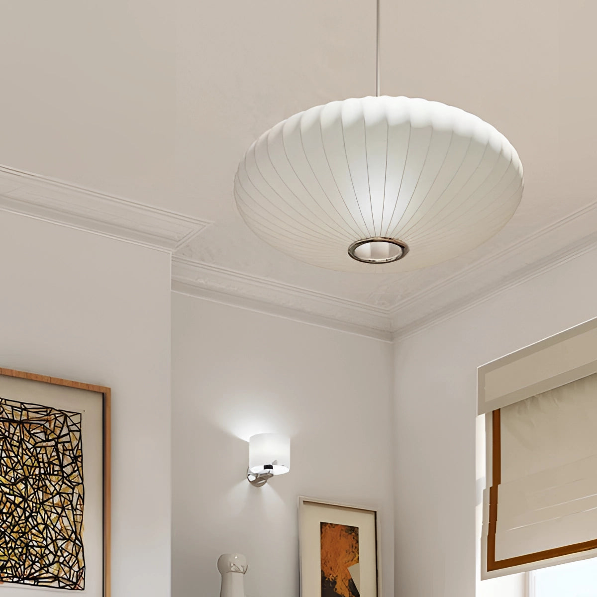 Modern oval pendant lights hanging in a contemporary dining room with hardwood flooring and picture frames on the walls, showcasing a sophisticated interior design.