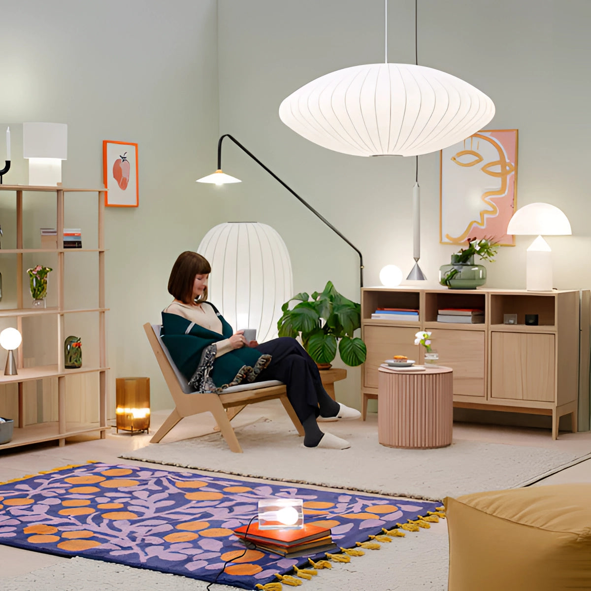 Modern oval pendant lights illuminating a contemporary dining room setting, featuring sleek interior design elements, wood flooring, and stylish furnishings with a touch of greenery.