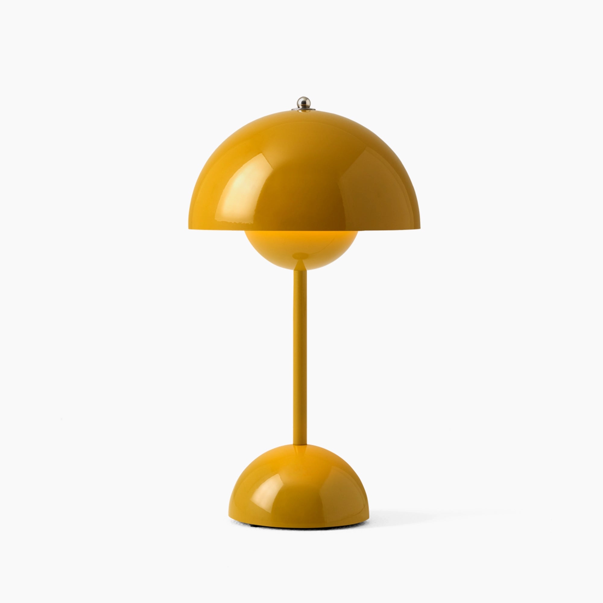 Modern peach table lamp with a minimalist spherical design featuring an adjustable yellow lampshade, placed on a simple base.