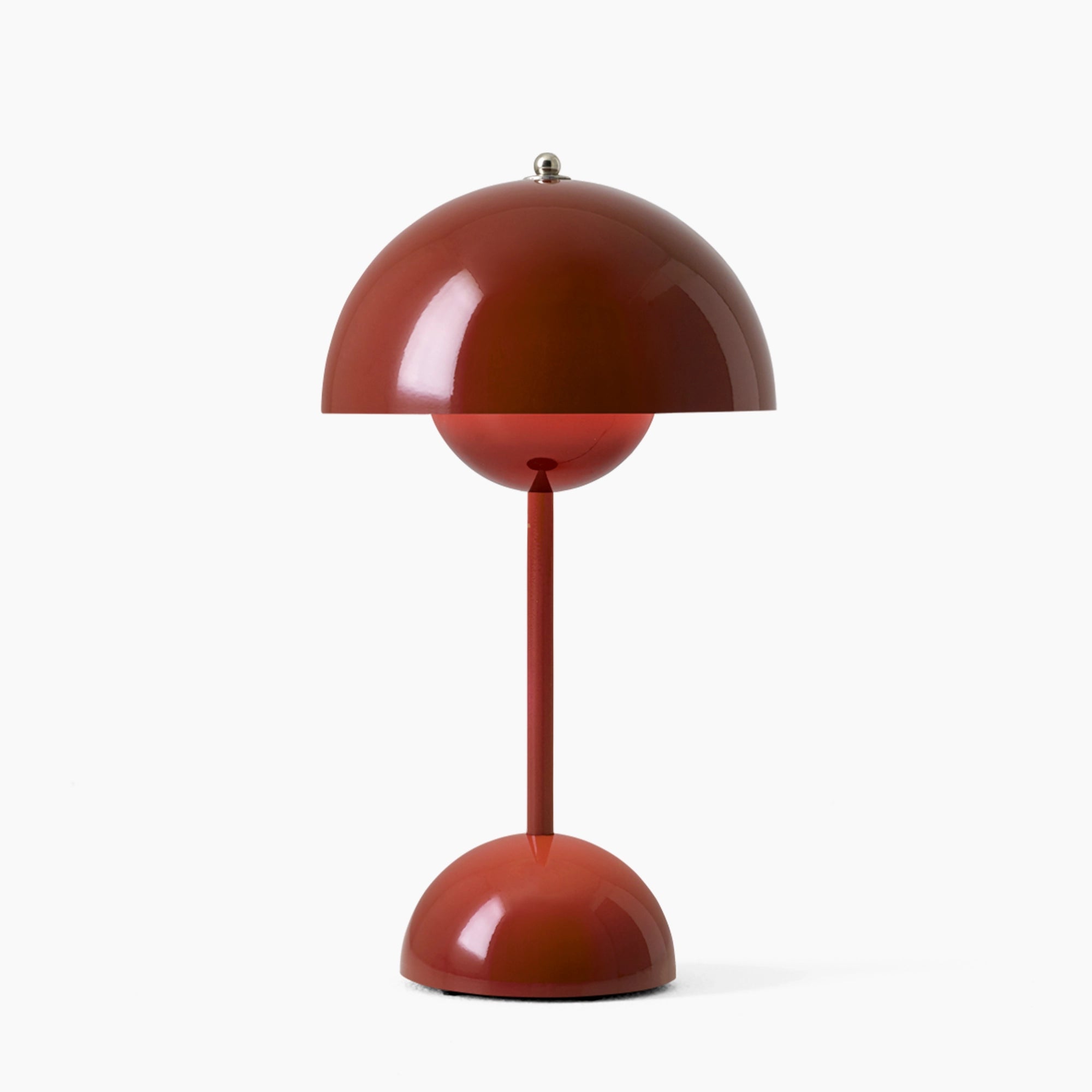 Modern peach table lamp with a minimalist design, featuring an adjustable spherical light and a red lampshade. The lamp has a circular base and a wooden accent, embodying a contemporary aesthetic.