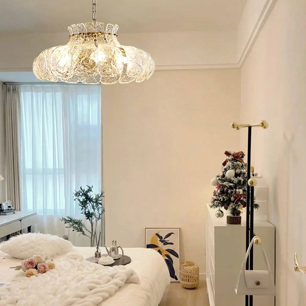 Modern pear glass chandelier with gold chain hanging in a stylish interior setting, featuring neutral grey and white tones, wooden elements, and decorative curtains, enhancing the room's luxury appeal.
