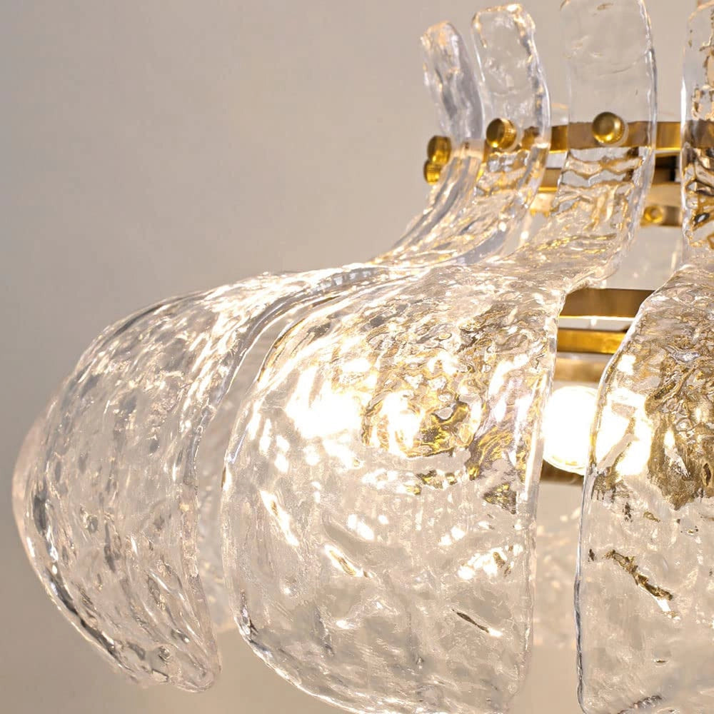 Modern pear-shaped glass chandelier featuring an elegant gold chain, showcasing an artistic design with transparent glass elements resembling a luxurious and contemporary piece of lighting decor.