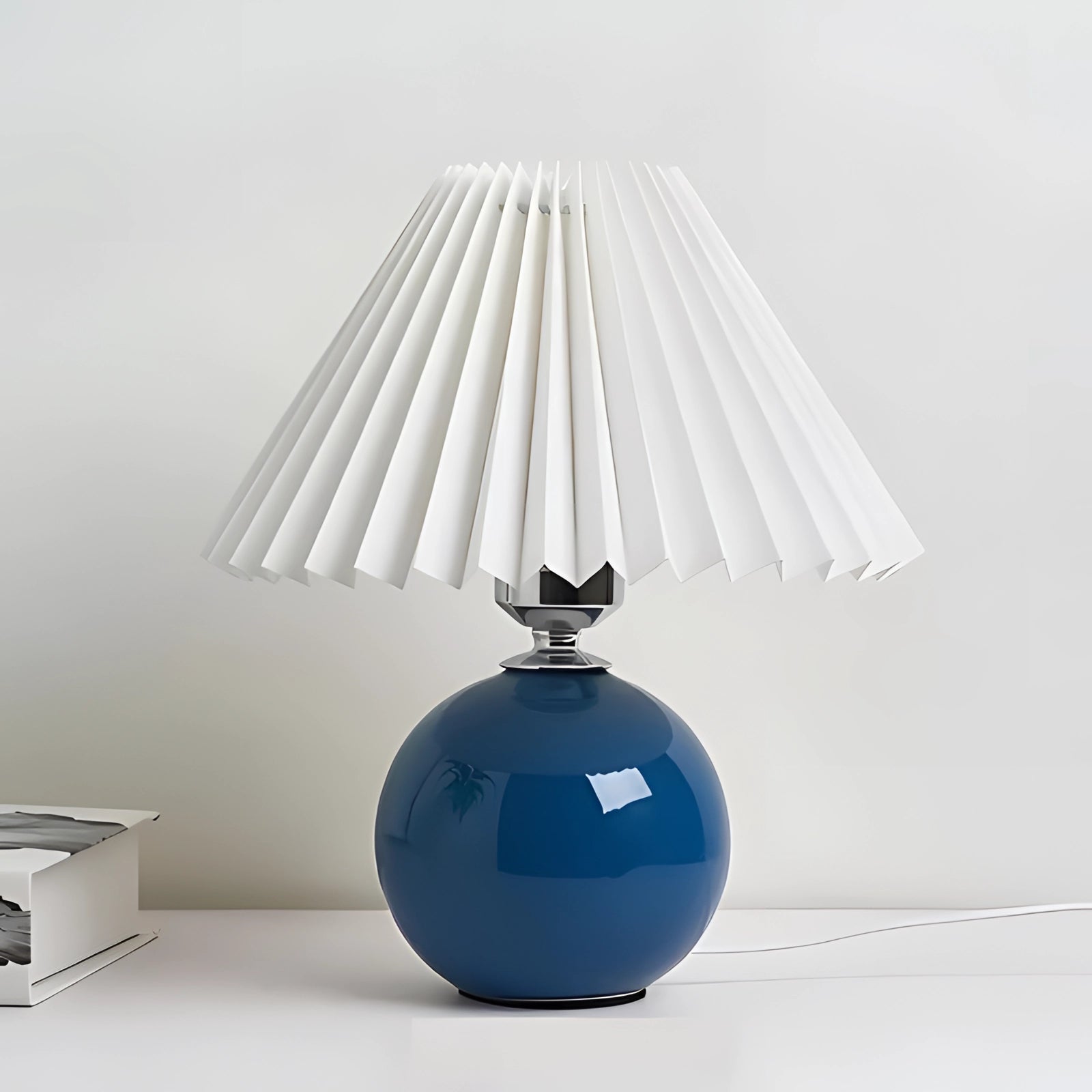Modern pink and white ceramic lamp featuring a pleated shade with Scandinavian design elements, displayed in an elegant setting with subtle electric blue accents.