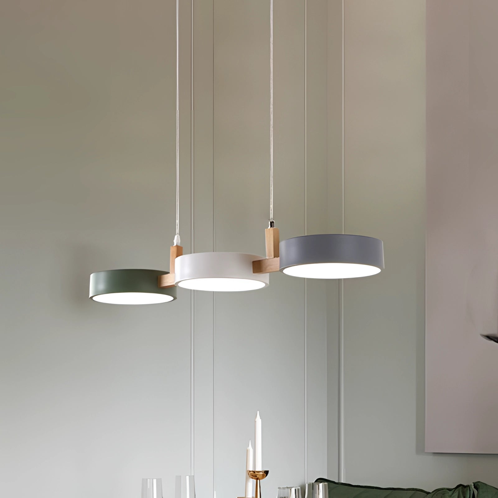 Modern Scandinavian adjustable triple pendant lights with wooden accents, featuring a sleek rectangular design and three shades, hanging from the ceiling over a dining room area.