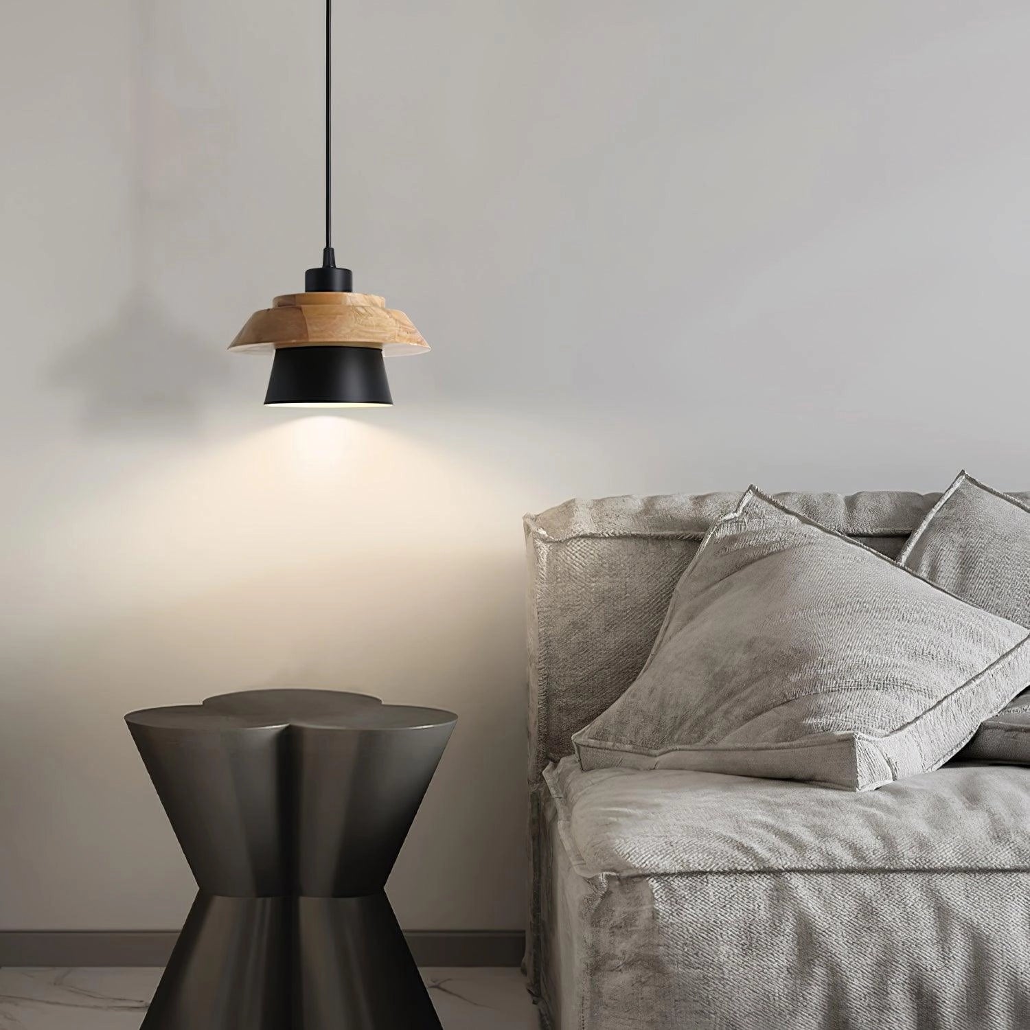 Modern Scandinavian black pendant lamp with a wooden accent, hanging above a kitchen table, providing stylish and contemporary lighting to the interior design.