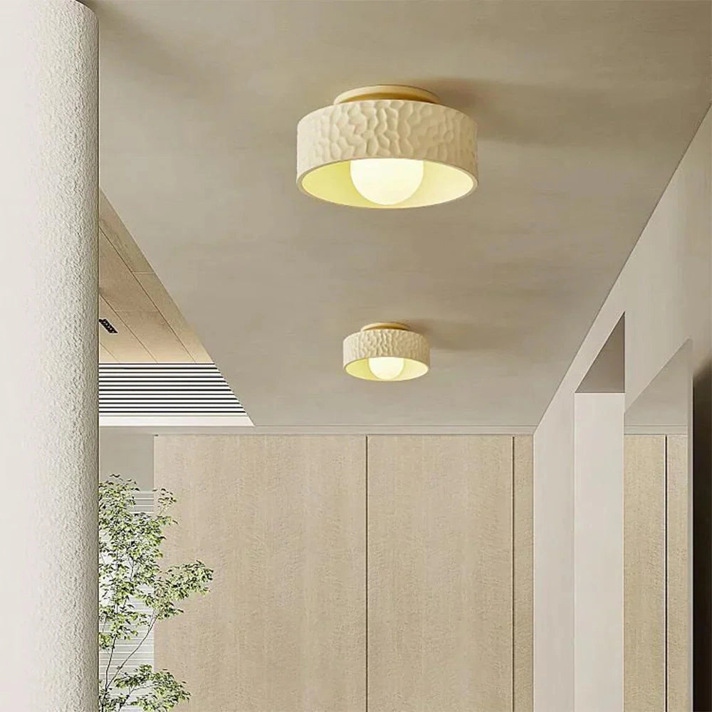 Modern textured circular LED ceiling light fixture with a flush mount design, featuring a wood-like finish and elegant shade, suitable for interior spaces.