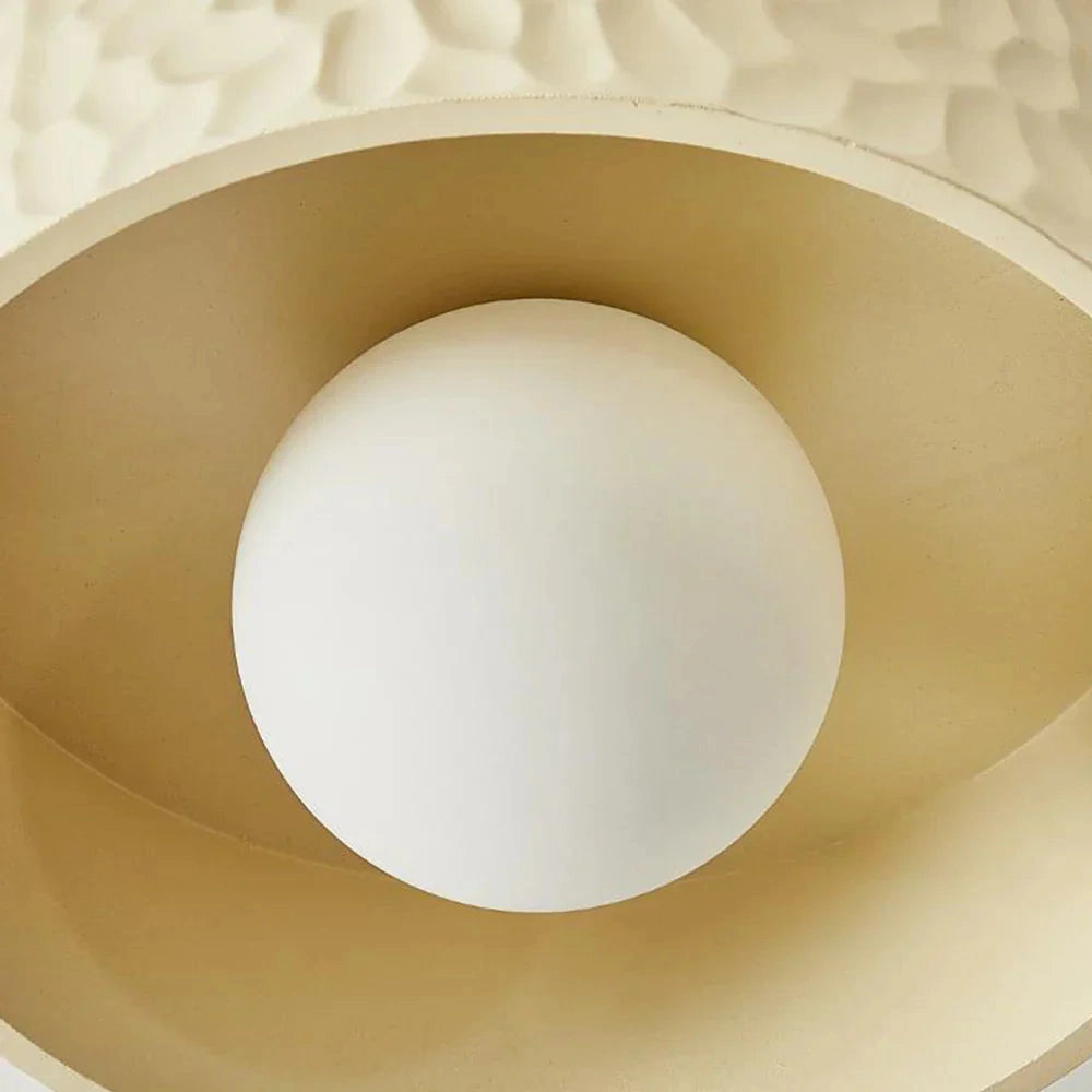 Modern circular LED ceiling light fixture with a textured surface, flush-mounted on a beige ceiling, featuring wood elements and a pattern that adds architectural interest.