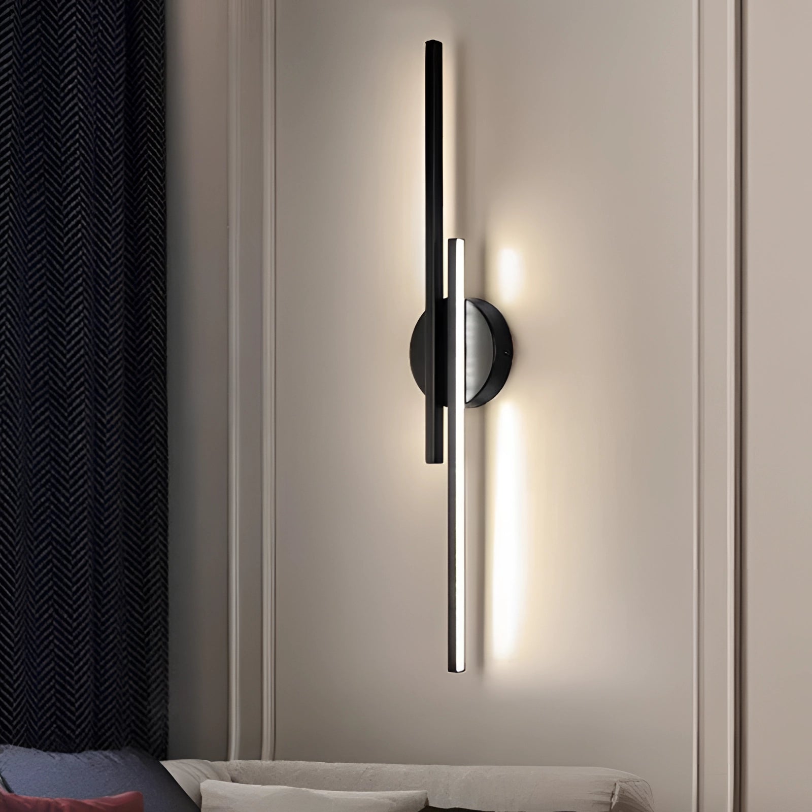 A black circular minimalist vertical LED wall sconce mounted on a wooden wall, showcasing modern interior design elements.