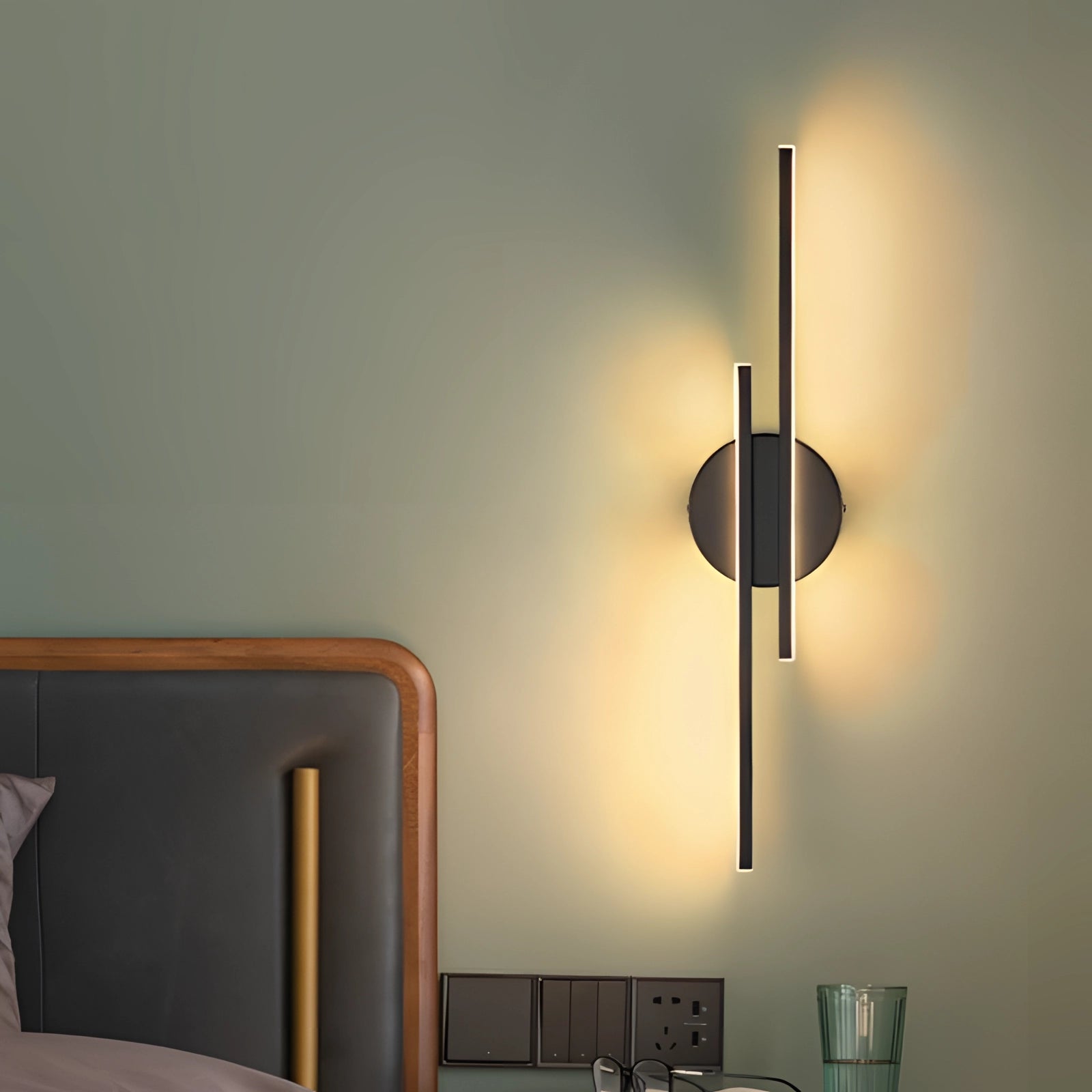 Modern black circular minimalist LED wall sconce mounted on a wooden surface, showcasing its sleek design and soft illumination.