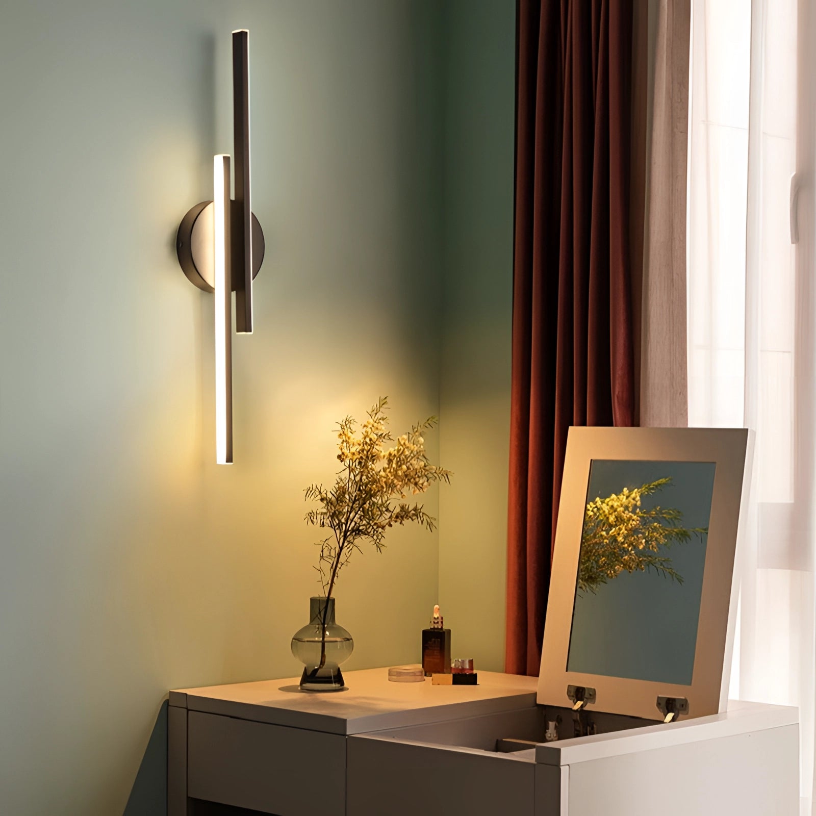 Modern vertical LED wall sconce in a minimalist black circular design mounted on a wall in a stylishly decorated interior space with a wooden table, desk, and potted plant.