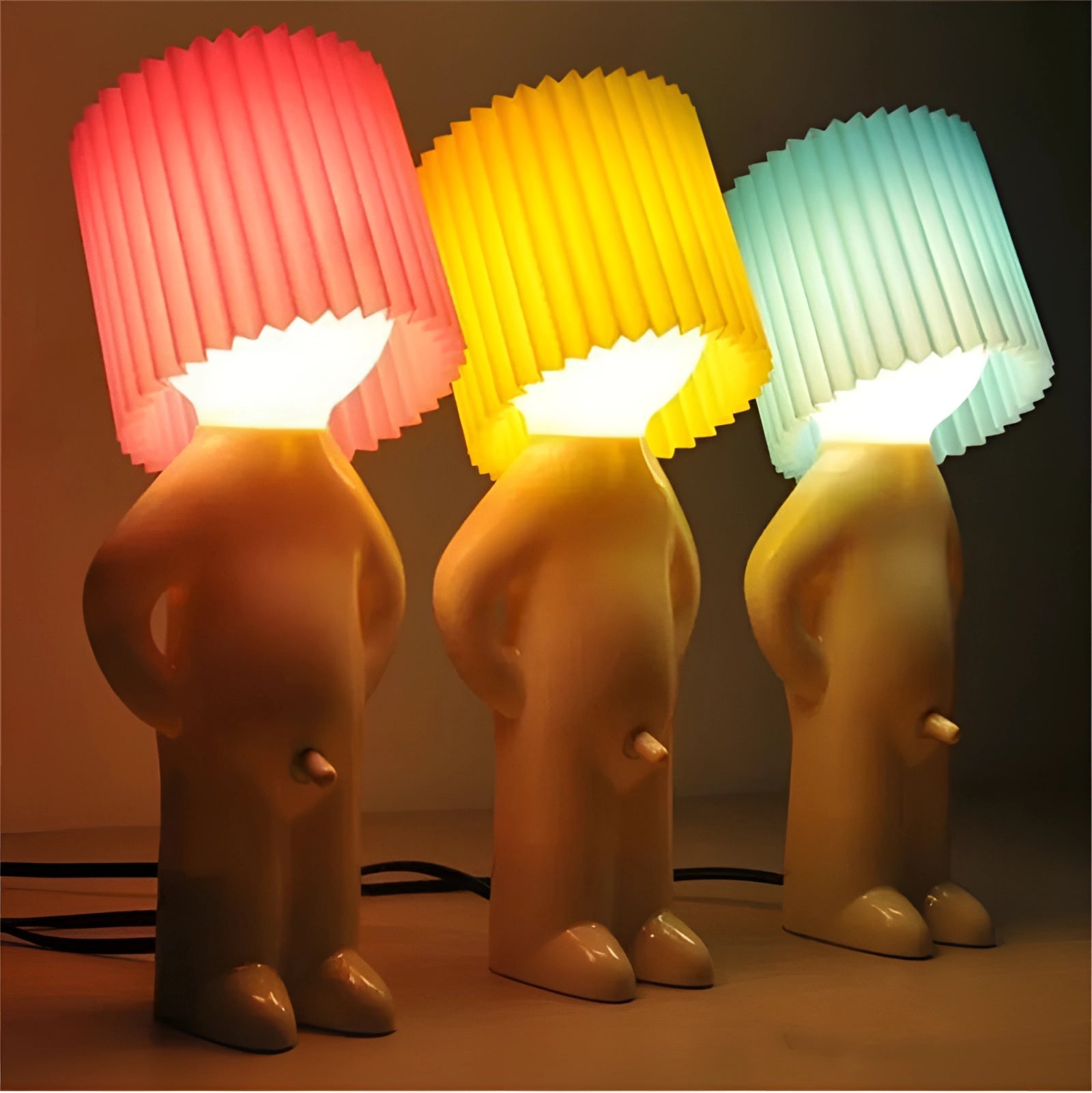 A blue novelty table lamp with a human-shaped design, featuring a cylindrical lampshade and resembling a quirky piece of art.