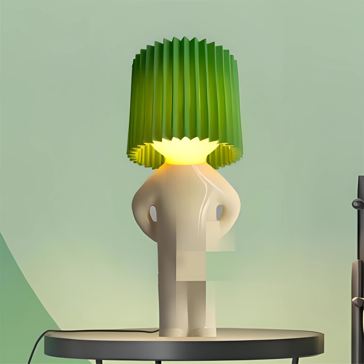 Green human-shaped table lamp with a cylindrical lampshade, designed as a quirky accent piece resembling a pedestal, blending art and functionality for unique interior lighting.