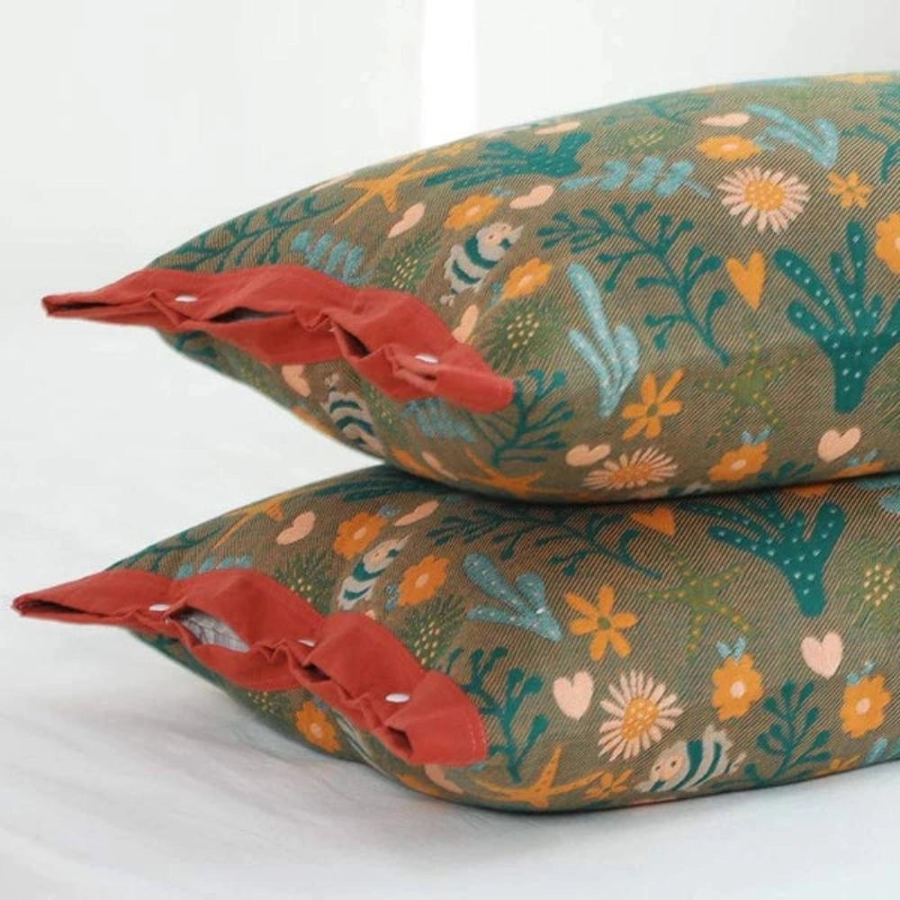 Ocean-themed throw pillows featuring vibrant fish and coral designs in shades of orange and peach, adding a nautical and artistic touch to home decor.