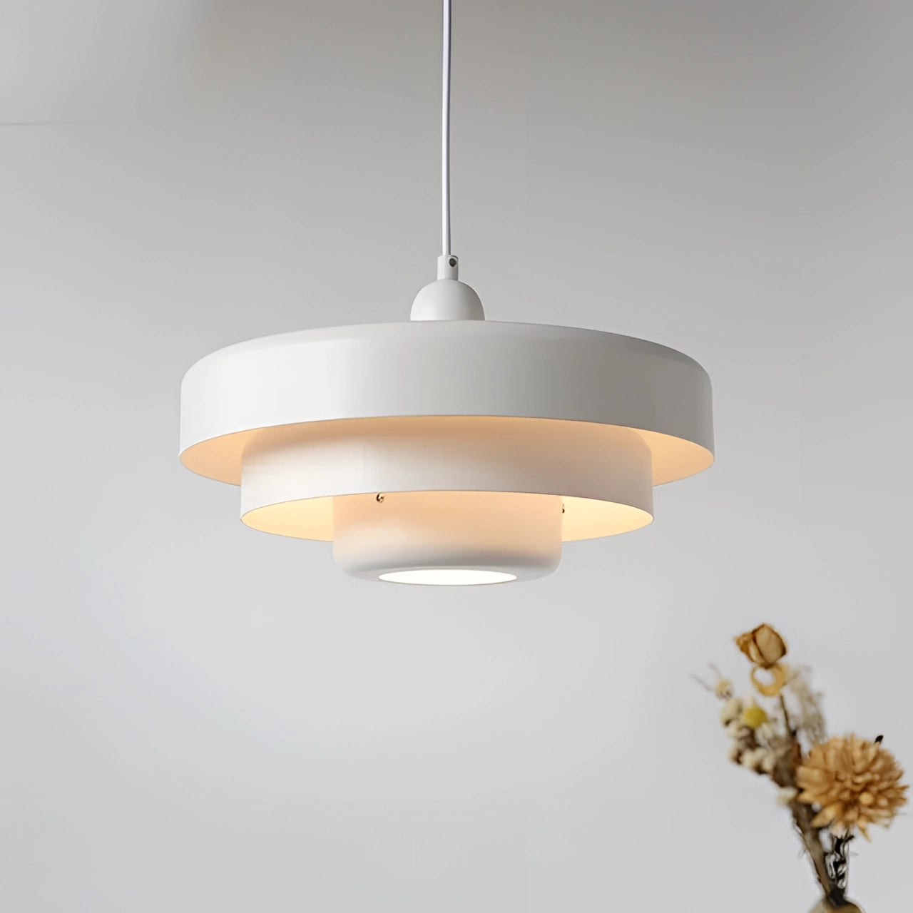 Mid-century modern Scandinavian pendant light with a white finish hanging from the ceiling.