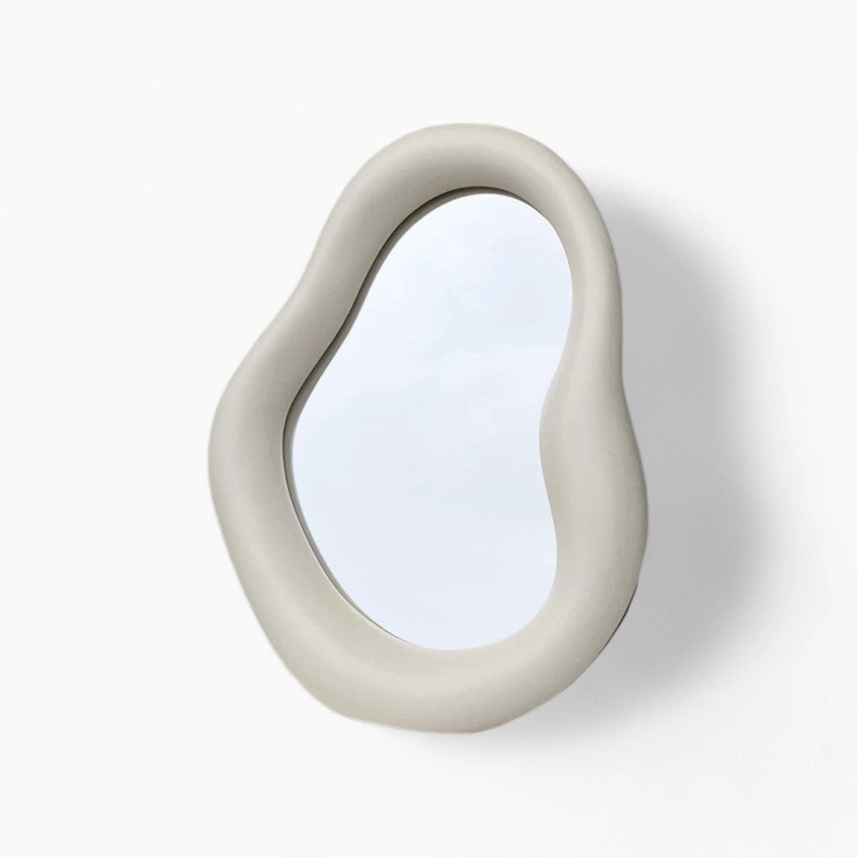 Organic asymmetrical mirror with a beige frame designed in a modern minimalist style, featuring a unique and artistic shape that resembles jewelry.