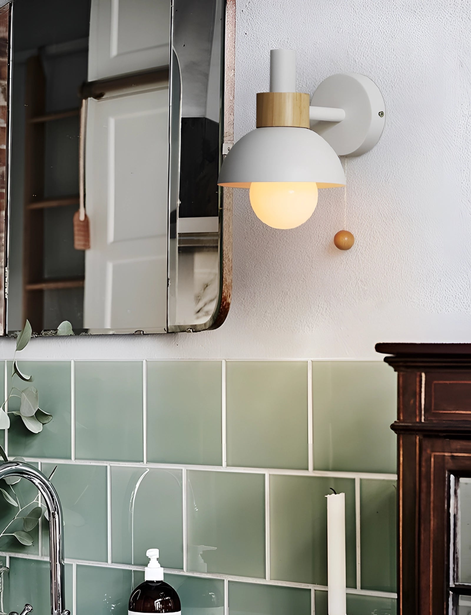 Pastel Scandinavian adjustable wall lamp in a minimalist color block design mounted on a white wall above wooden cabinetry and shelving in a modern kitchen interior.