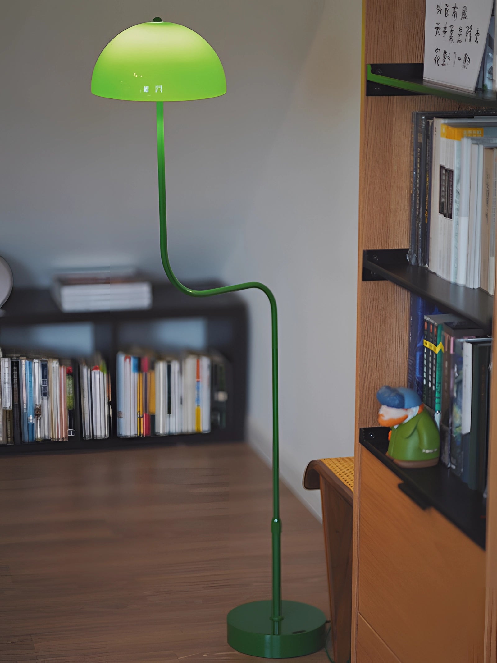 Retro Art Deco green brass floor lamp placed in an elegant interior setting, featuring wooden shelving and a bookcase against the wall.
