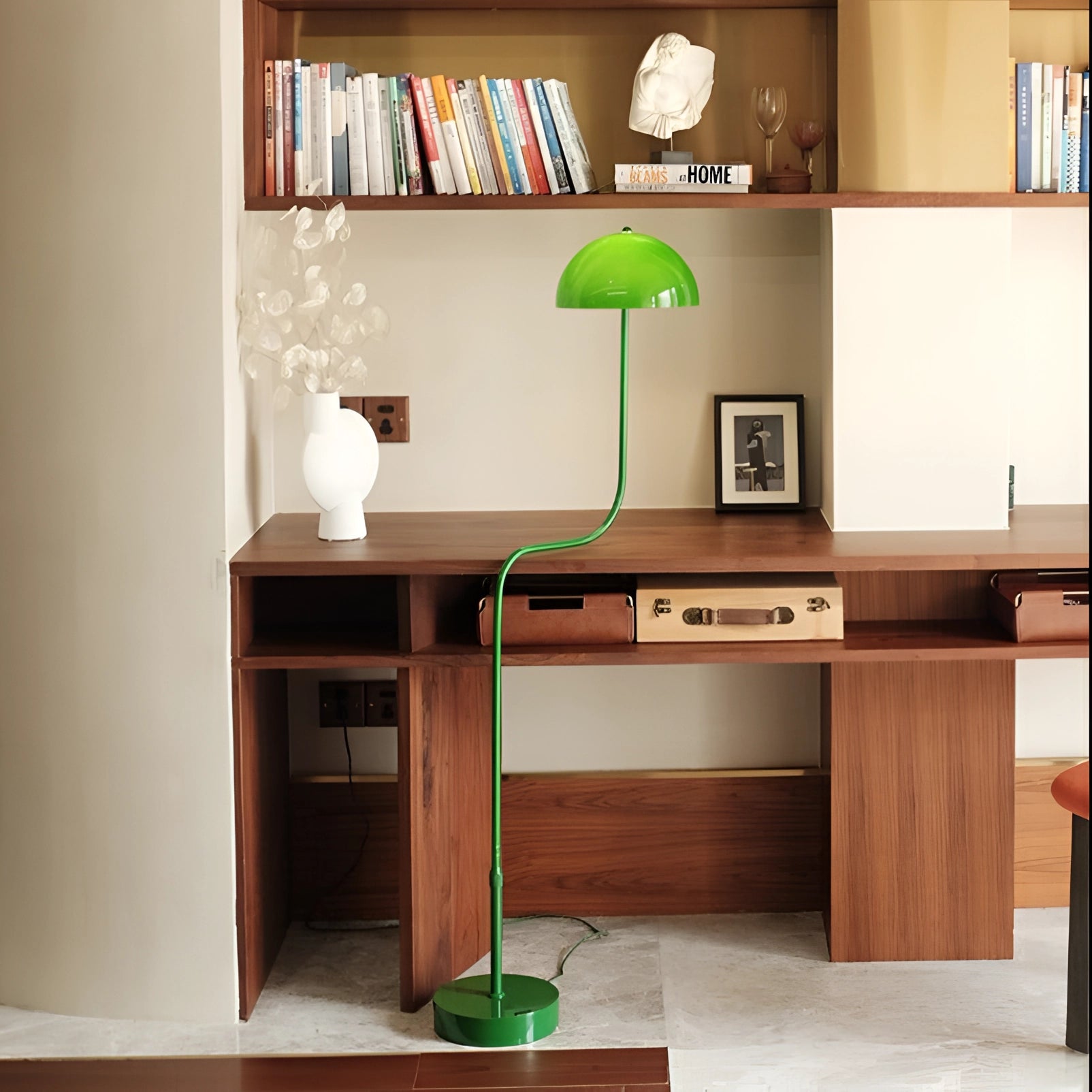 Elegant retro Art Deco green brass floor lamp placed in a stylish interior setting with a mix of wooden furniture, including shelves and a desk, enhancing the home decor ambiance.