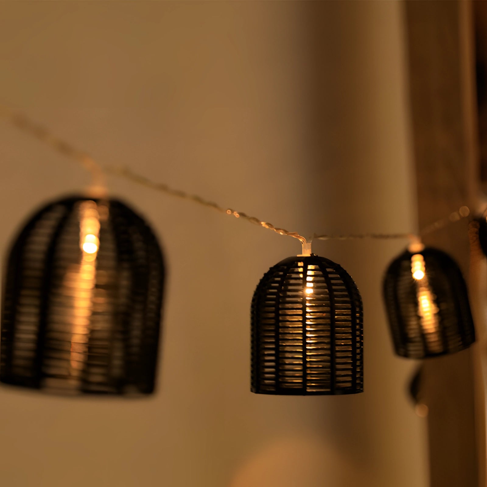 Outdoor weatherproof retro industrial metal cage string lights with amber glow, showcasing a series of bulbs encased in metal cages, perfect for creating a warm and vintage ambiance.
