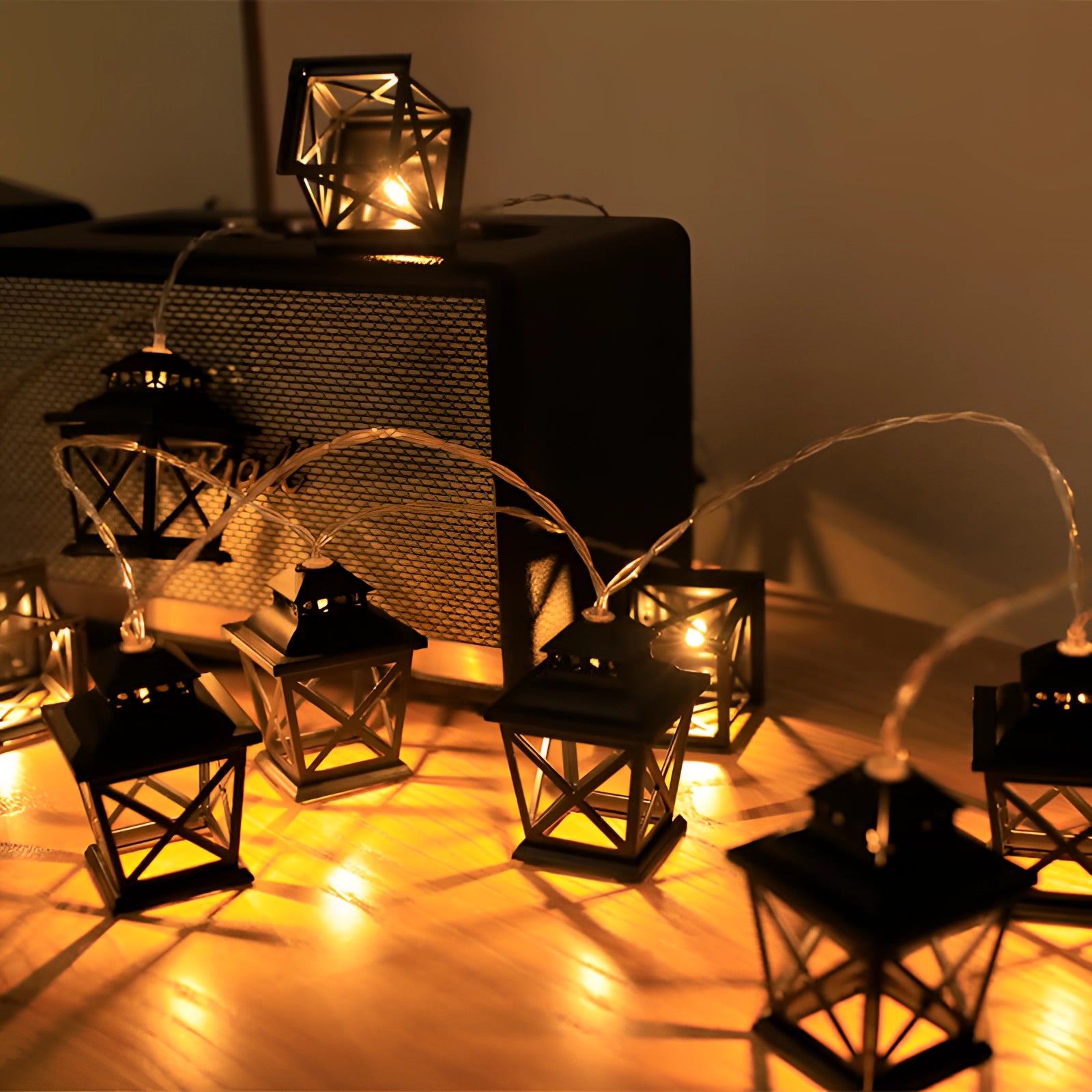 Retro industrial metal cage string lights featuring a series of 20 LED bulbs on a 3-meter strand, designed for outdoor use with a weatherproof build. The image captures the lights illuminating a dark setting, showcasing their vintage metal cage design and warm glow, perfect for creating an artistic and atmospheric ambiance in outdoor spaces.