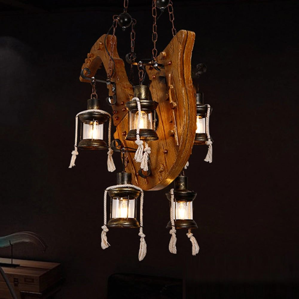 Rustic wooden wheel chandelier with vintage farmhouse design, featuring amber light bulbs, metal accents, and a wooden wheel structure, hanging as a unique ceiling fixture.