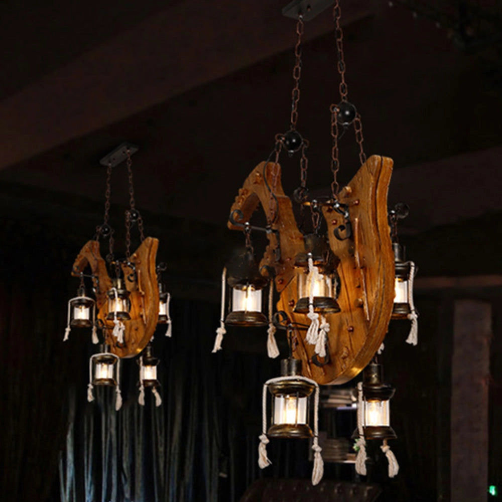 Rustic wooden wheel chandelier with vintage farmhouse design featuring metal accents and ambient lighting.