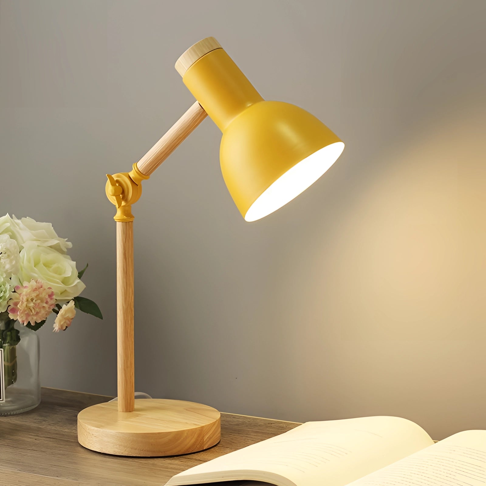Scandinavian adjustable wooden desk lamp with a minimalist black shade and a yellow base, elegantly positioned next to a decorative plant in a vase, showcasing a blend of natural wood texture and modern design.