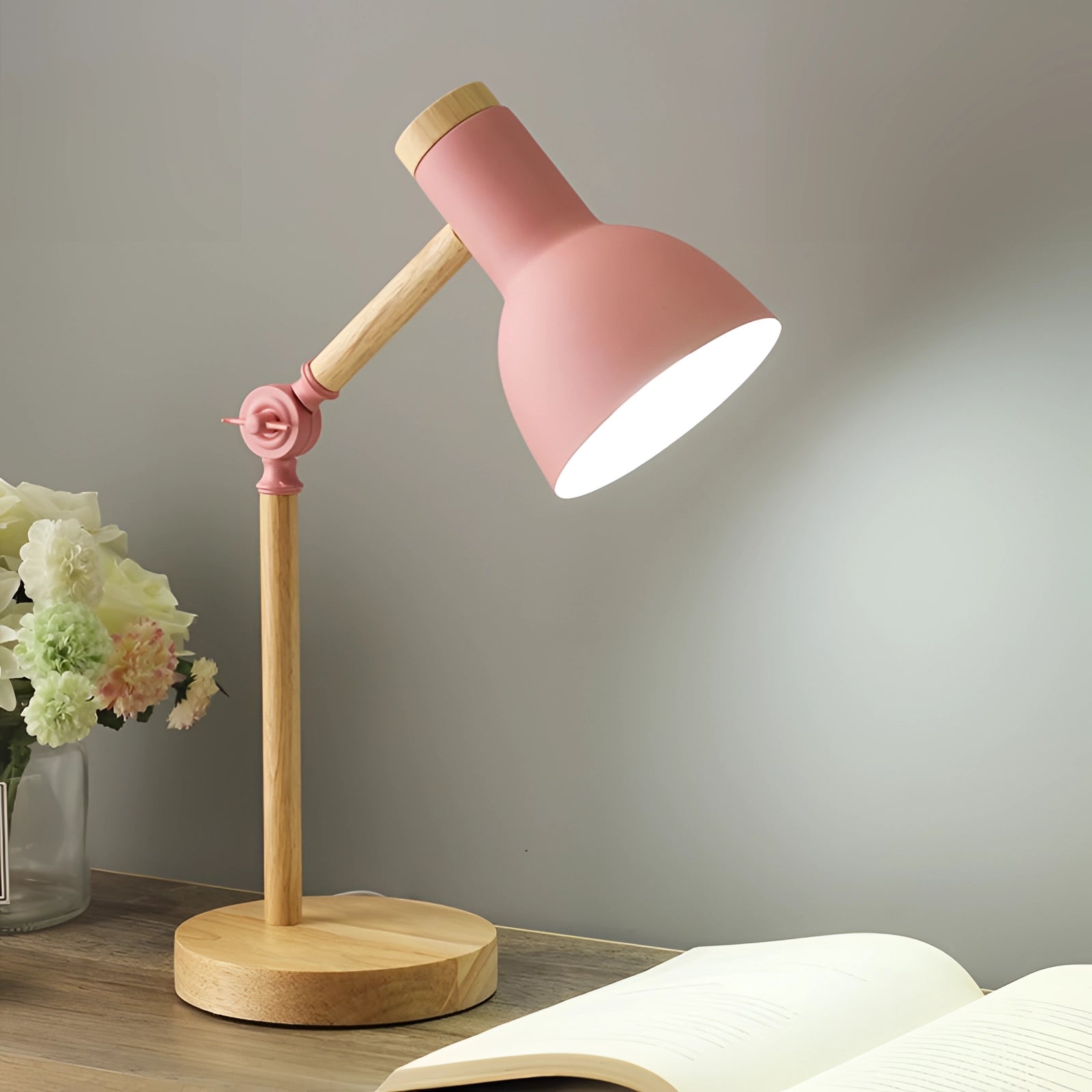 Scandinavian-style adjustable wooden desk lamp featuring a minimalist black shade and a rose-colored accent, designed for LED lighting, with a sleek and balanced structure suitable for a modern table setting.