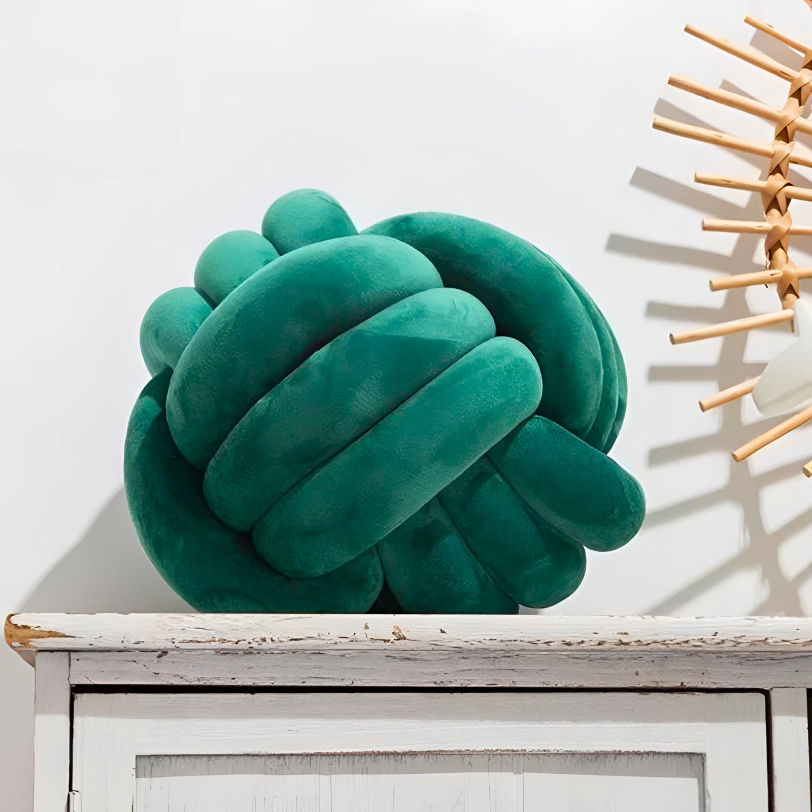 A green Scandinavian Knot Pillow made from soft velvet fabric, intricately designed as a modern decorative cushion.