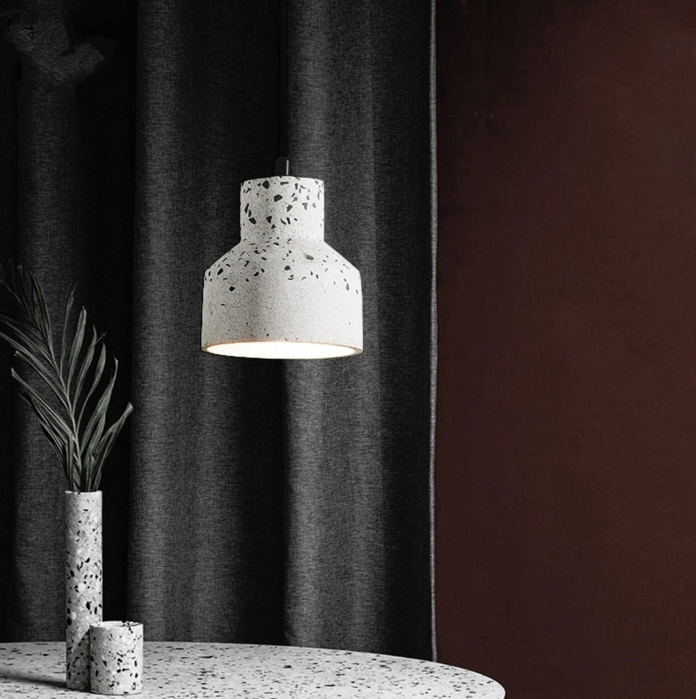 Scandinavian Terrazzo Pendant Lights hanging above a modern minimalist interior with a potted houseplant and wooden elements in the background.